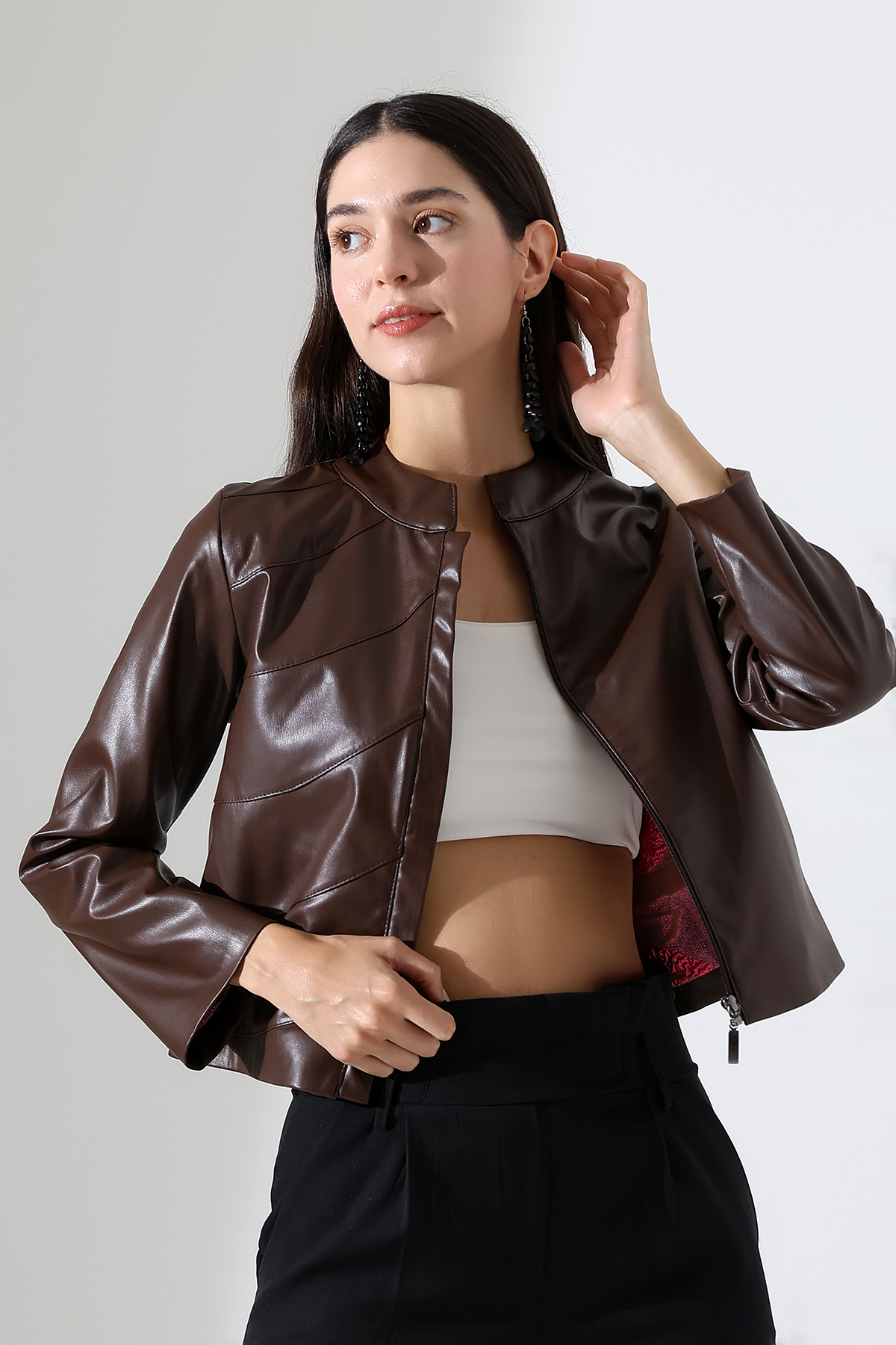 Mannequin en veste courte en similicuir marron ouverte sur le devant